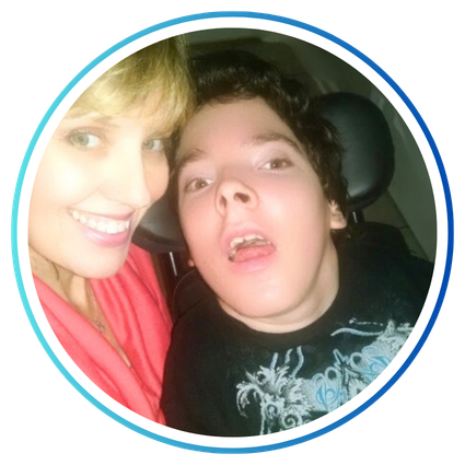 Sabrina Kimball smiling beside her son, Greyson Channing, seated in his wheelchair.